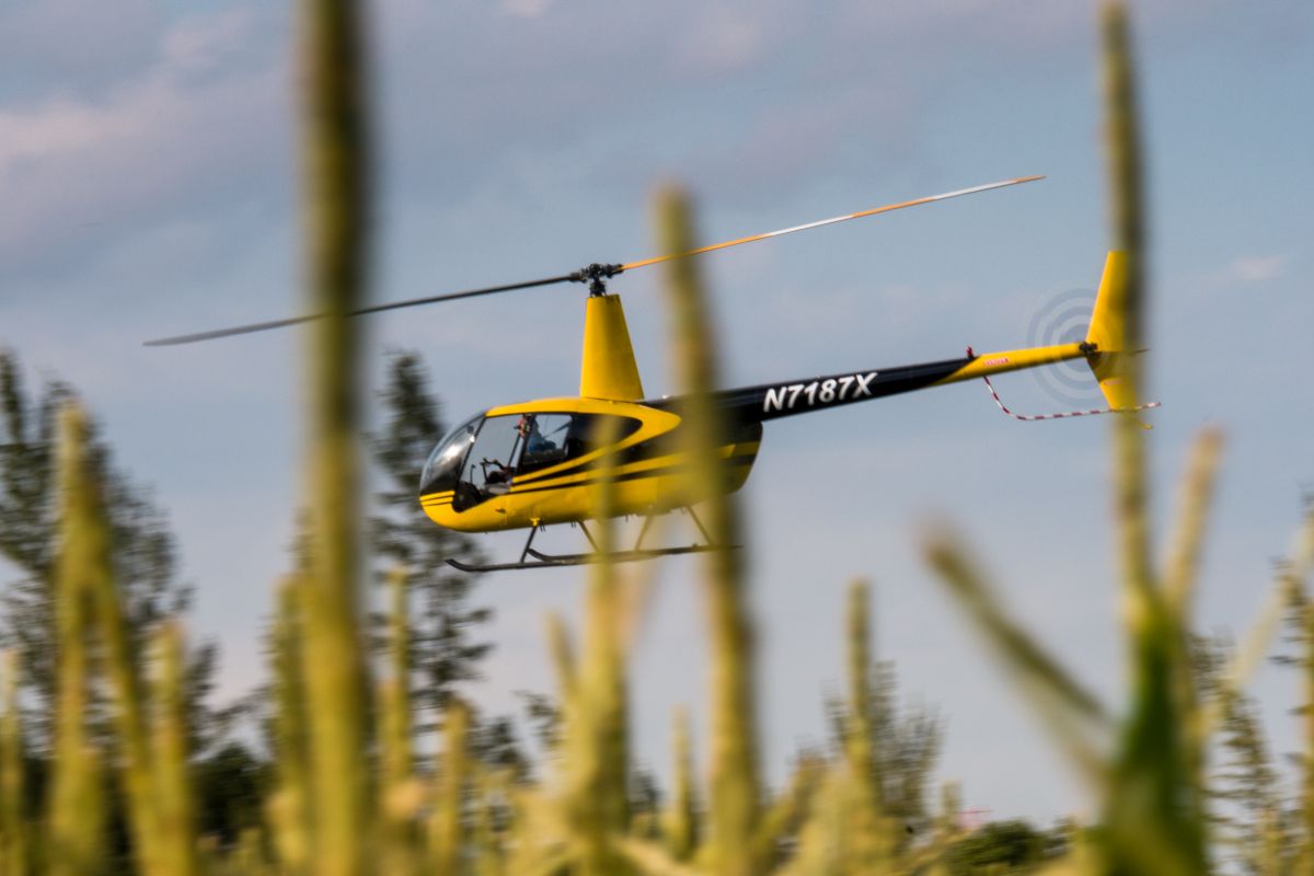 Helicopter performing agricultural work over farmland