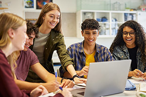 Students collaborate around a computer