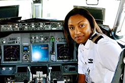 pilot in front of a hangar with her plane inside