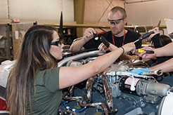 plane technician checking a small aircraft engine