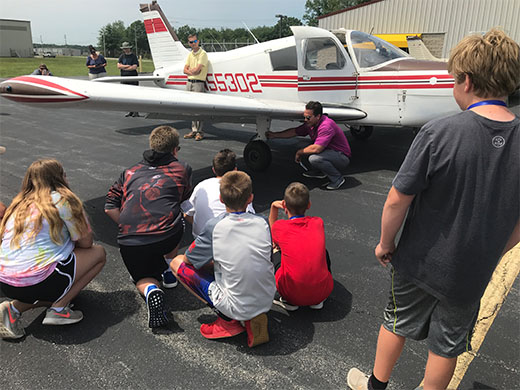 illustration of a group of kids learning how to do a fuel inspection