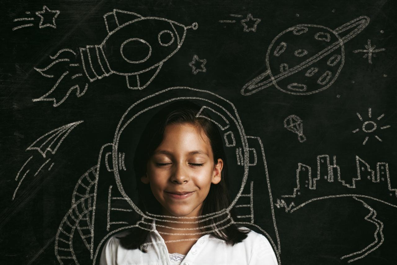 girl in front of chalkboard with space drawings on it 