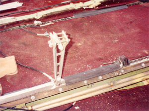 "Photo of cabin center section. Close view of separated seat leg still attached to floor. Photo from NTSB/FAA investigation."