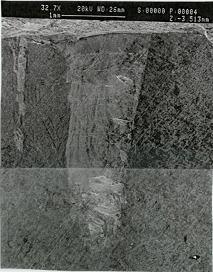 "Magnified view of tierod hole wall. View depicts numerous small parallel surface cracks (ladder cracks) aligned with the longitudinal axis of the hole."