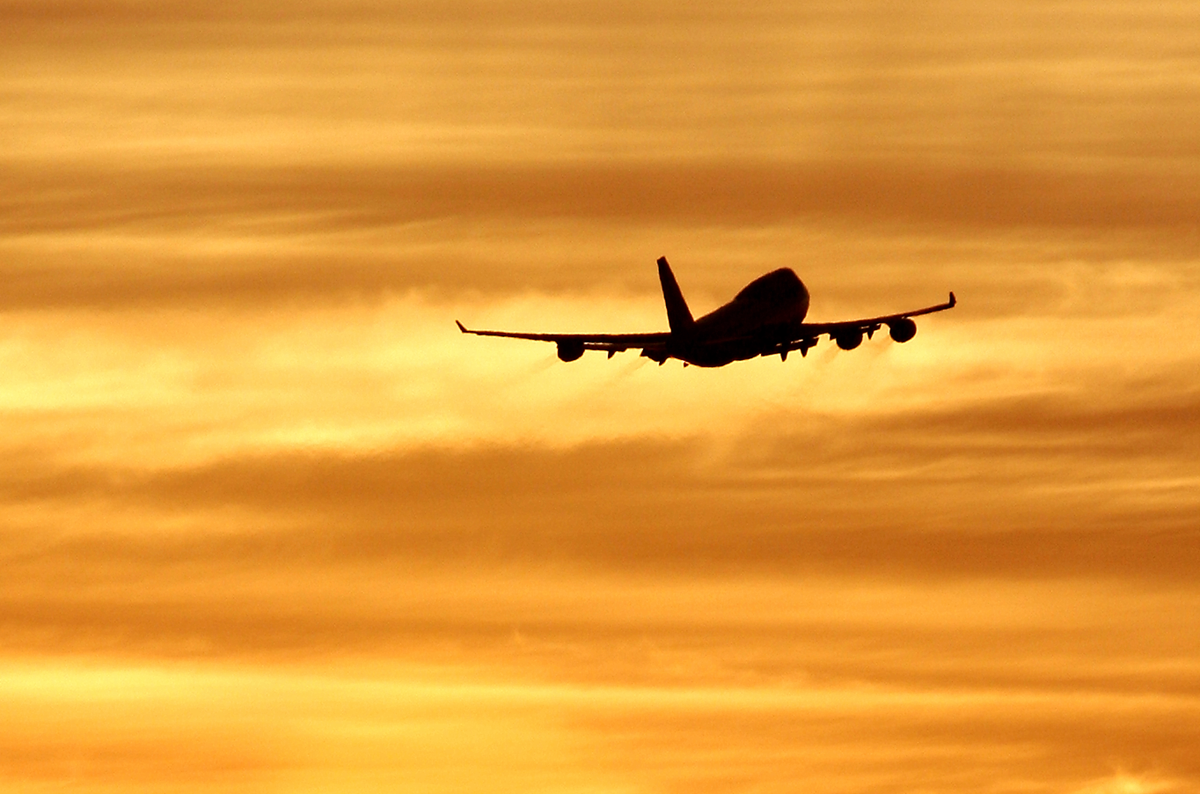 airplane taking off at sunset