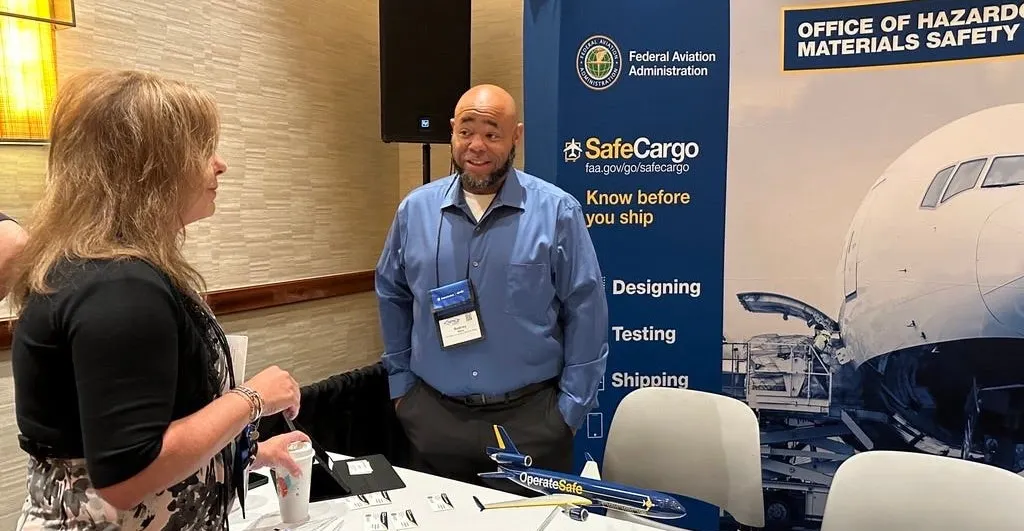 FAA principal hazardous materials aviation safety inspector Rodney Myles assists an attendee at a hazmat safety convention. (Photo: FAA)