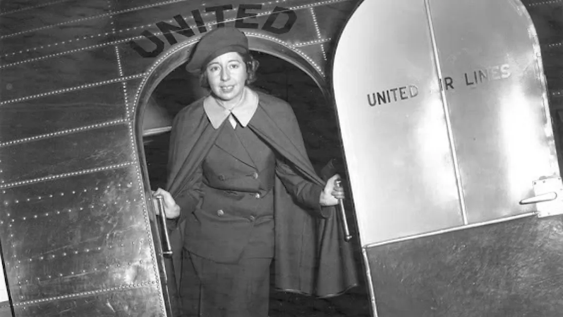 Ellen Church, the first flight attendant, stands on a United Airlines plane. A registered nurse and licensed pilot, Church’s legacy influences aviation safety and passenger wellbeing to this day. (Photo courtesy of the Association of Flight Attendants)
