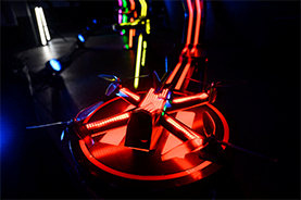 illuminated racing drone in a darkened stage