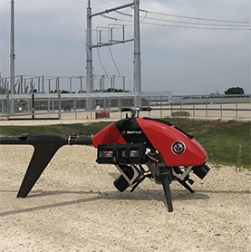red drone on ground near power station