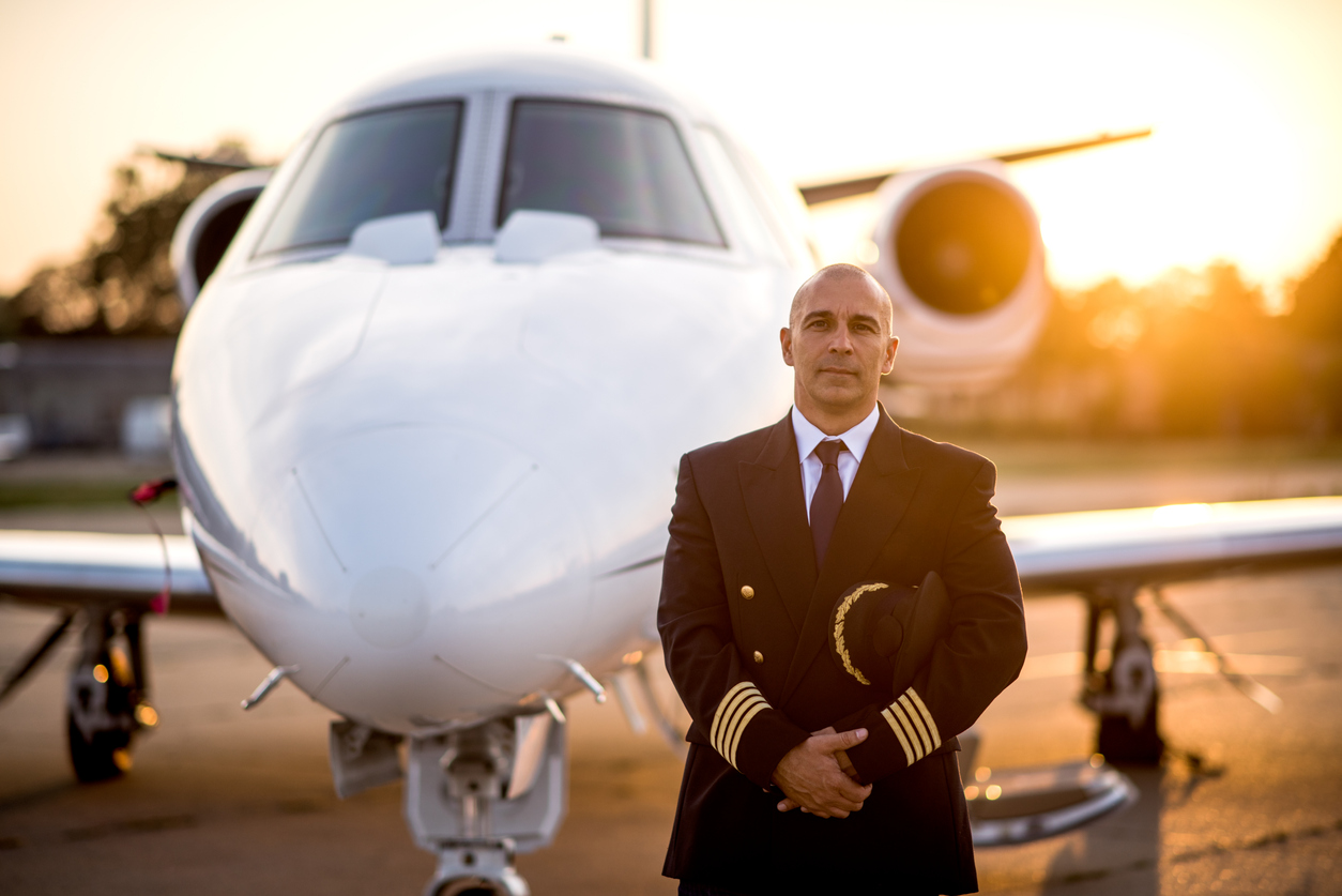 Pilot with plane over orange sky