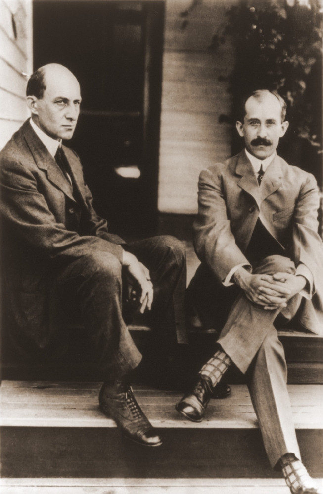 Wilbur and Orville Wright sit on the porch steps of their house in Dayton Ohio, 1909.