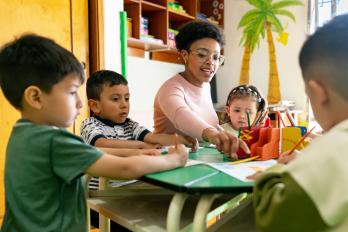 children and teacher at classroom table