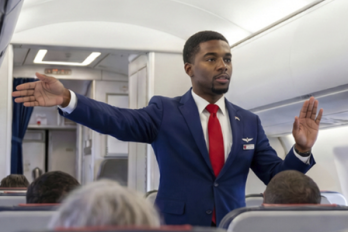 A flight attendant leading evacuation instructions on a crowded plane
