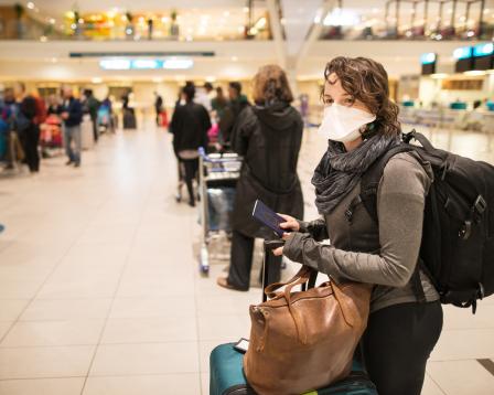 Woman wearing a mask standing in line at airport