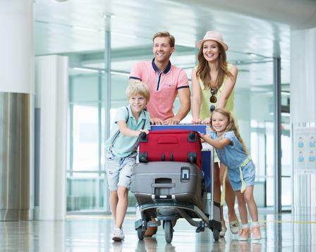 A family at an airport traveling for the summer