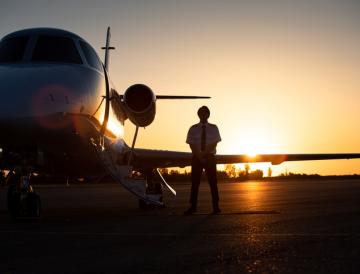 man and plane backlit by sunset