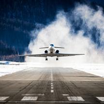 Airplane flying with snow on the ground